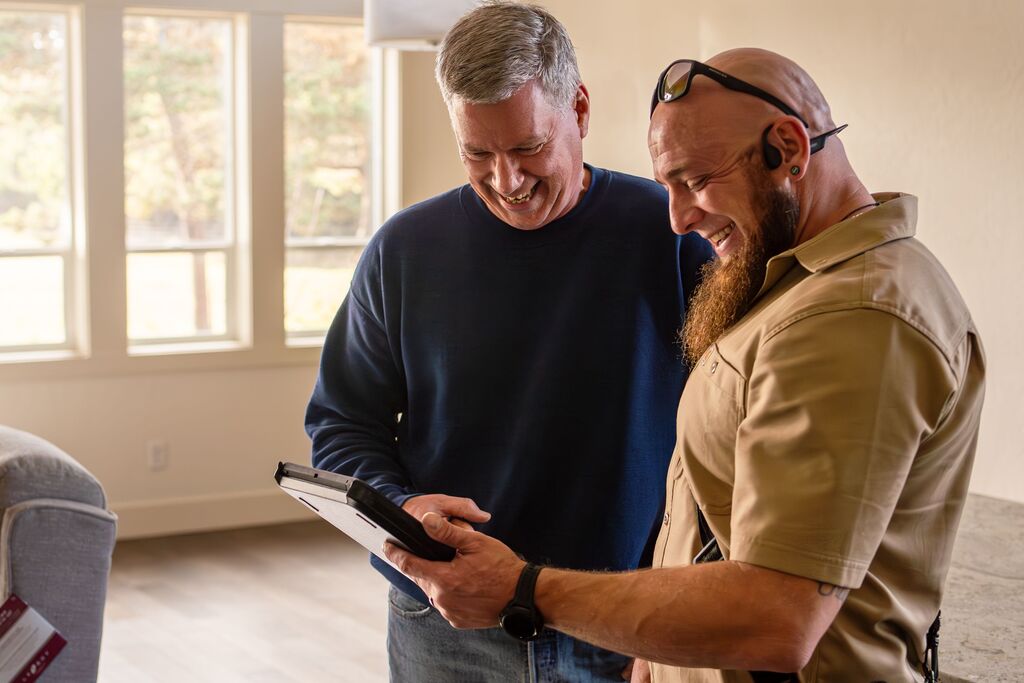HVAC technician talking with a homeowner about AC maintenance in Bandon summer.