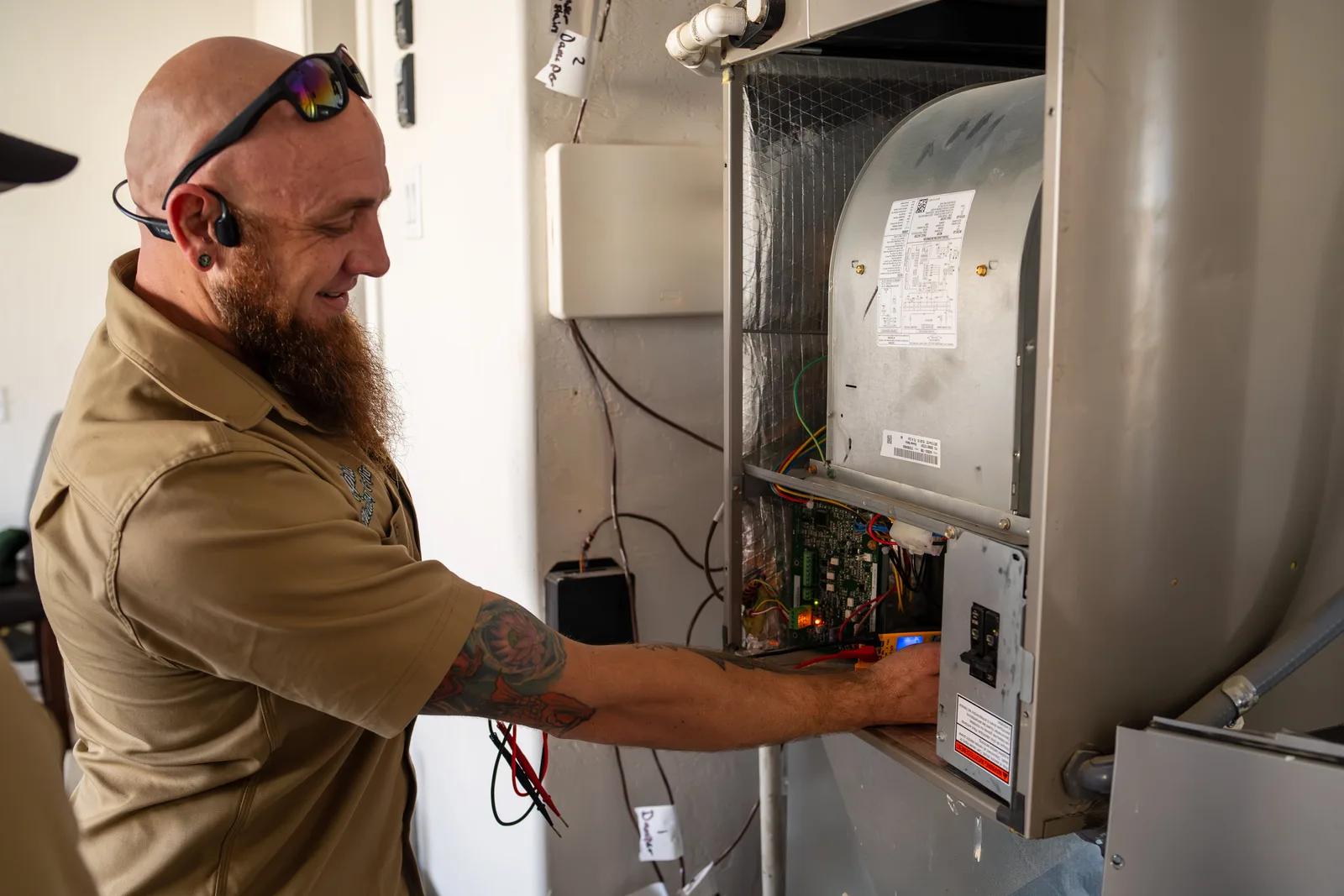 Technician inspecting a furnace in a Bandon home to diagnose startup smells and heating system odors.